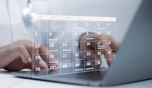A healthcare professional reviewing a calendar on their laptop.